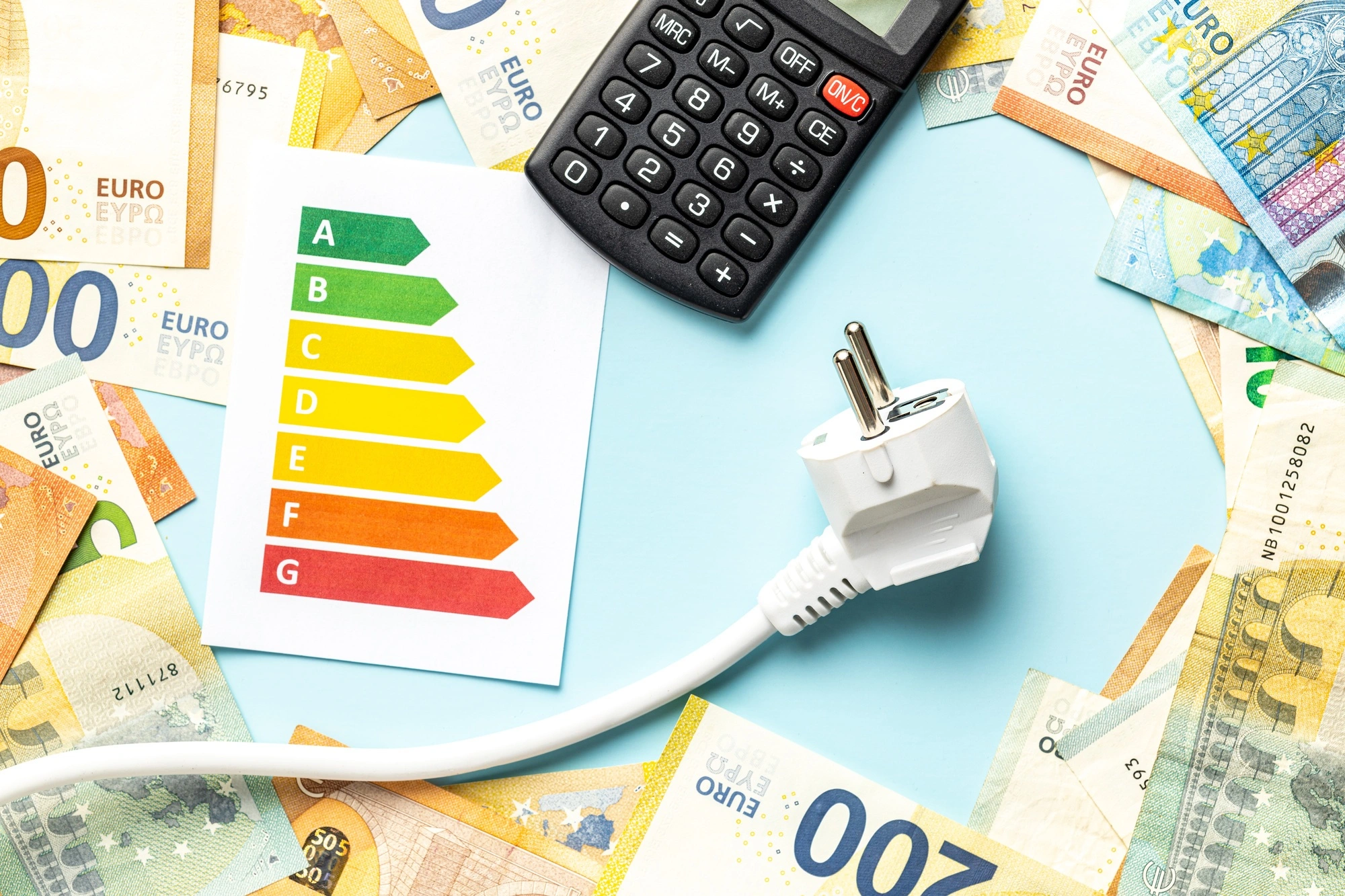 A calculator, euros and an electric cable to illustrate the calculation of the LCOE and the cost of energy